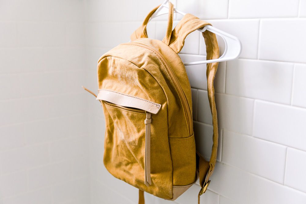 pottery barn kids yellow backpack hang dried in the bathroom - can you wash pottery barn backpacks - how to wash pottery barn backpack 